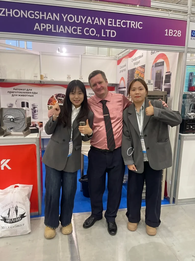 Zhongshan Youya'an Electric Appliance (UCK) team with a B2B client at their food dehydrator manufacturer booth during IEAE Russia.